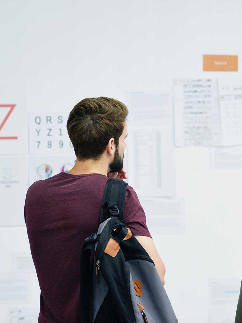 Illustration for Compass of Design depicting a person staring at a wall covered in printed designs.
